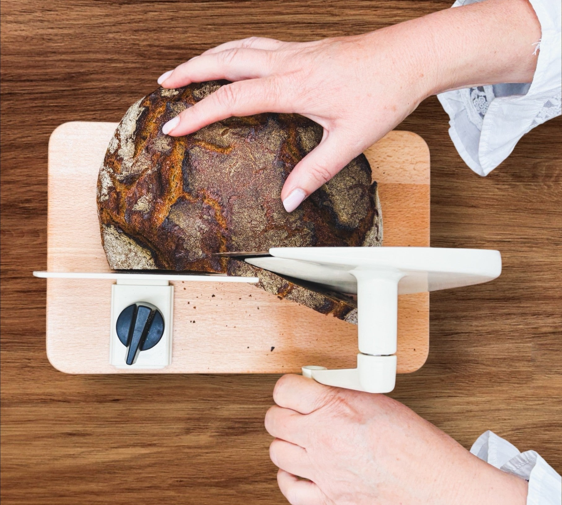 Manueller Allesschneider in der Farbe beige mit Brot von Jupiter.